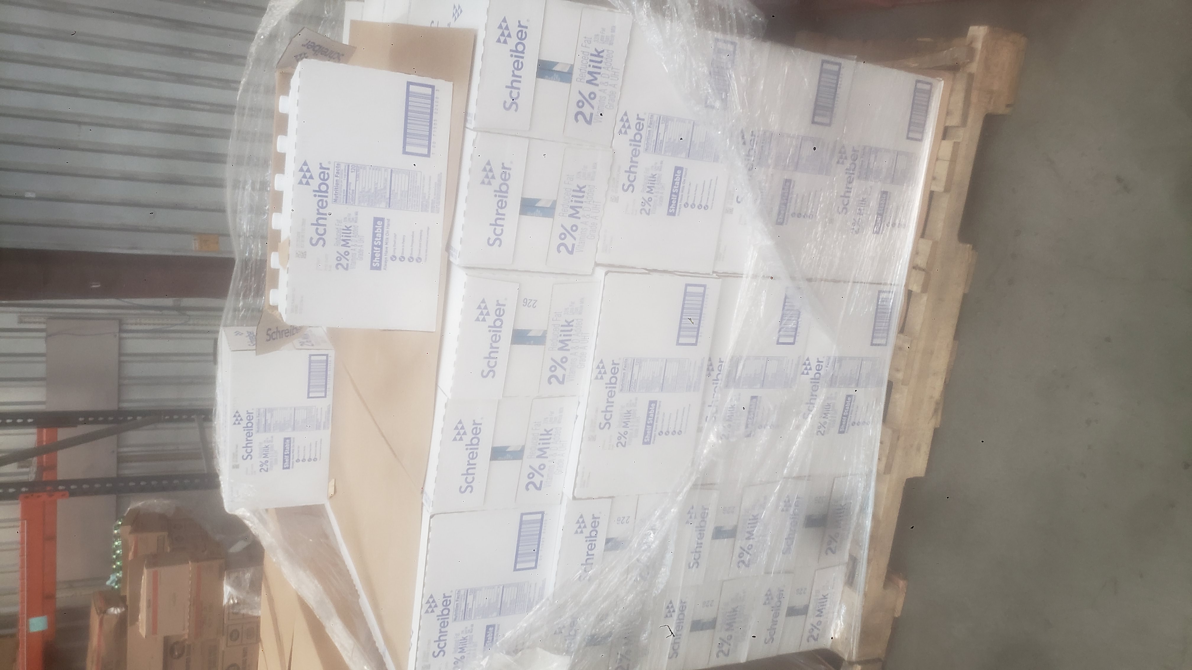 Cardboard boxes of 2% reduced fat milk covered in plastic wrap and on a pallet.